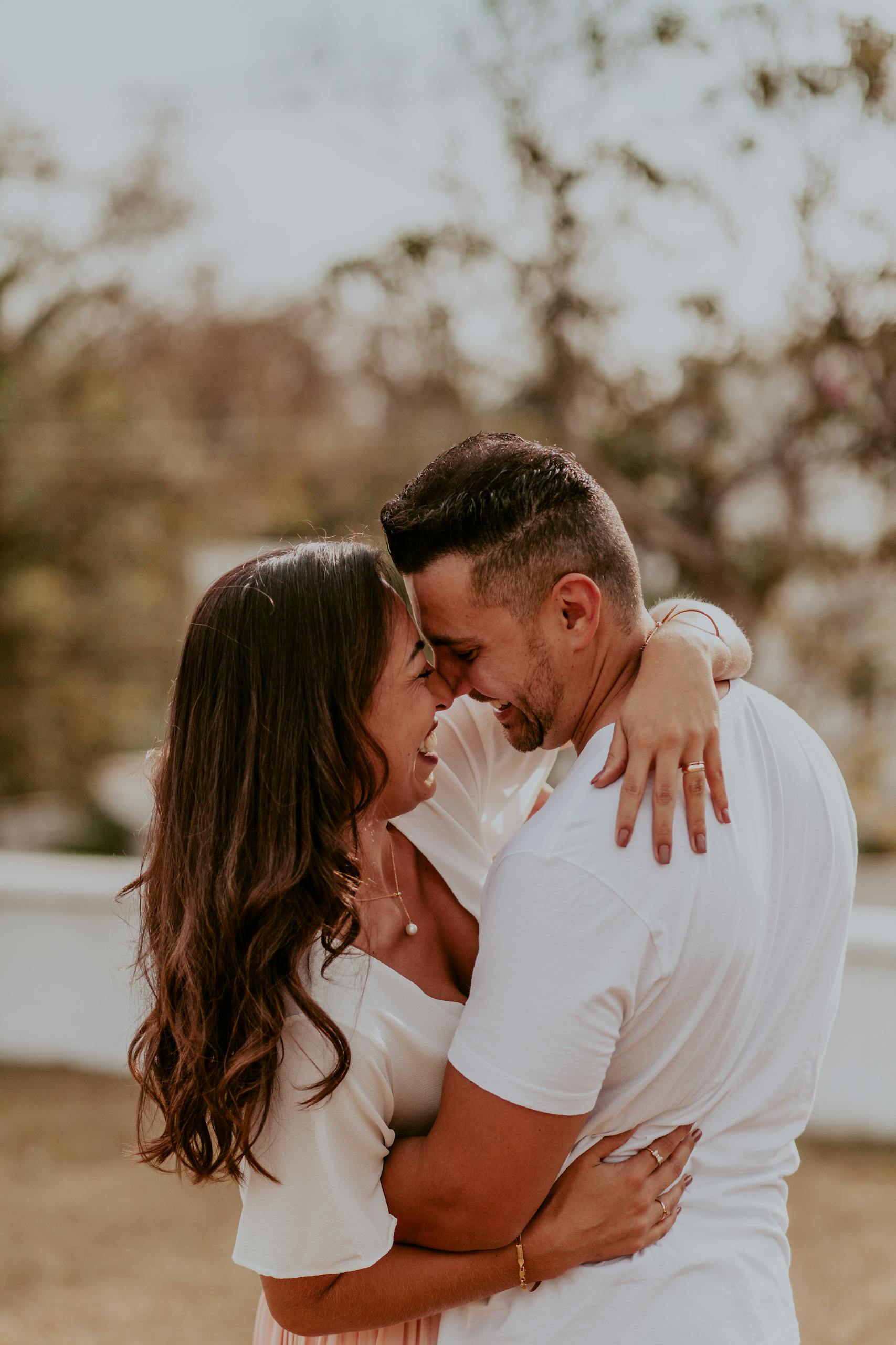 A joyful couple embracing outdoors, capturing intimate and happy moments together in summer.